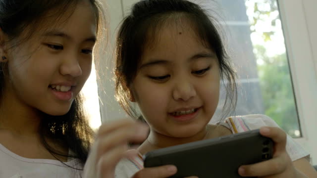 4-K-asiatische-Mädchen-Spiele-auf-Smartphone,-glückliche-Zeit-zusammen