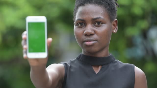 Teléfono-de-muestra-joven-empresaria-africana-hermosa-al-aire-libre