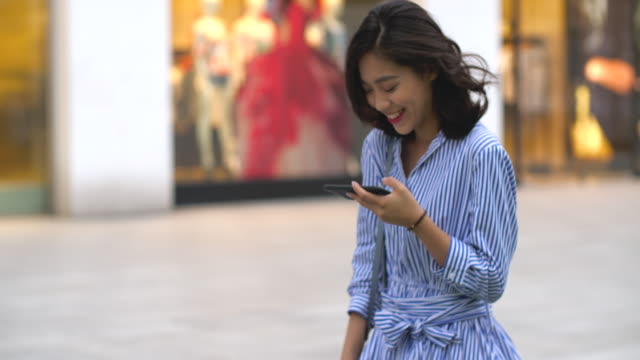 Happy-woman-using-phone-in-the-city,-4k