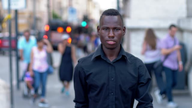 Glückliche-junge-Afro-Amerikaner-in-Straße-lächelnd-in-die-Kamera