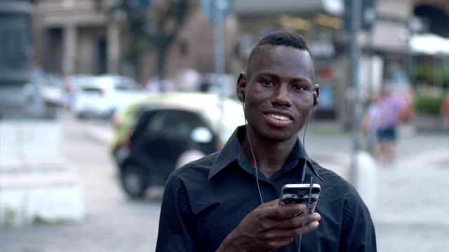 Porträt-des-jungen-schwarzen-afrikanischen-Mann-auf-der-Straße-Musik-hören-und-tanzen