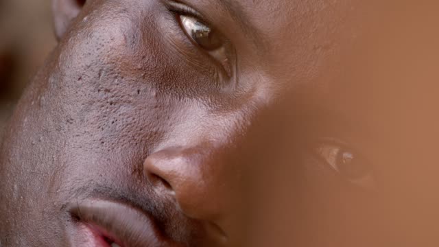 Porträt-von-depressiv-traurig-schwarzen-amerikanischen-jungen-Mann-starrte-auf-Kamera-Wand-gelehnt-hautnah