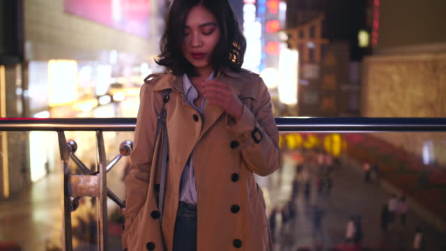 Slow-Motion-für-eine-hübsche-junge-Asiatin-berühren-ihr-Haar-in-der-Stadt-bei-Nacht