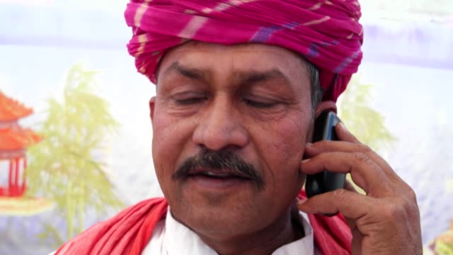 Handheld-Nahaufnahme-eines-Mannes-reden-Ernst-auf-seinem-Handy-in-Rajasthan