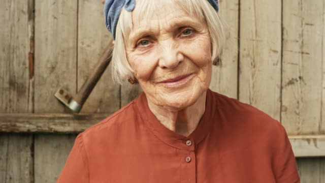 Ältere-Frau-posiert-gegen-Holzwand