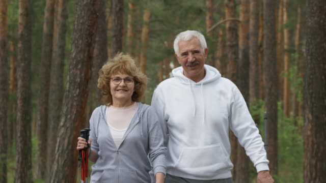 Glückliche-ältere-Menschen-wandern-im-Wald