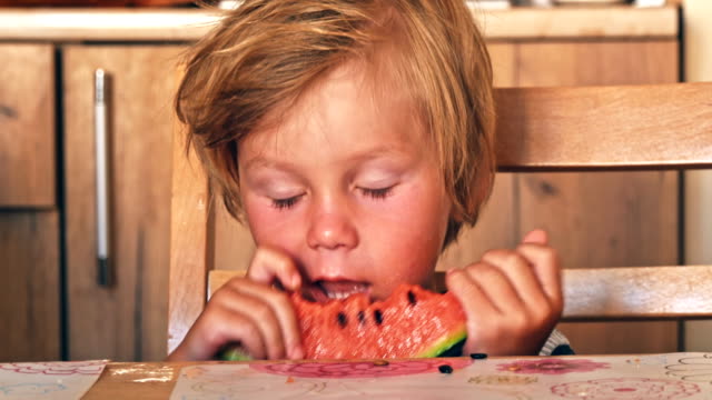 Glückliche-Kinder-mit-großen-roten-Stück-Wassermelone