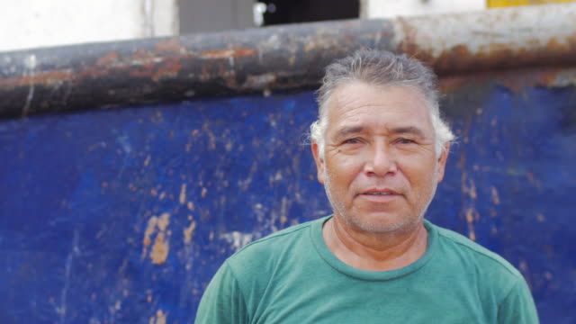 Close-up-Portrait-eines-älteren-Mannes-hispanic-Erbe-lächelnd-vor-einem-angedockten-Boot-in-Mexiko
