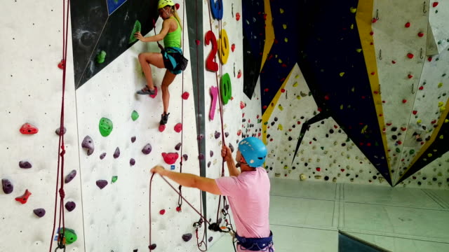 Sporty-couple-of-climbers--at-bouldering-gym