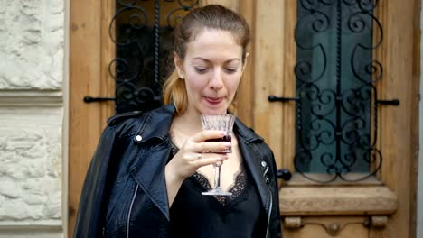 Junge-Frau-trinkt-Wein-aus-einem-Kristallglas-und-genießt-einen-Drink.-Freizeit-von-erfolgreichen-Menschen-auf-der-Straße.