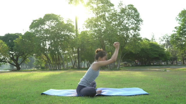 Young-asian-woman-yoga-outdoors-keep-calm-and-meditates-while-practicing-yoga-to-explore-the-inner-peace.-Yoga-and-meditation-have-good-benefits-for-health.-Yoga-Sport-and-Healthy-lifestyle-concept.