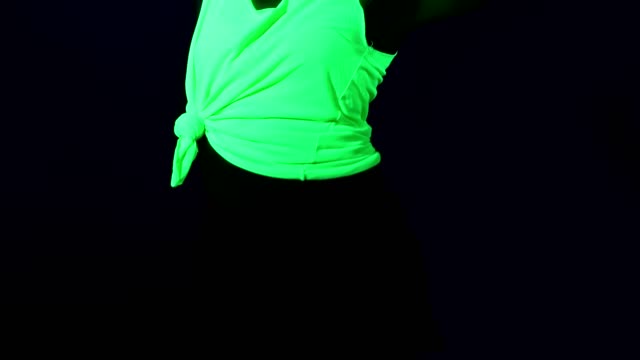 Woman-with-UV-face-paint,-wig,-glowing-clothing-dancing,-body-shot.-Caucasian-woman.-.