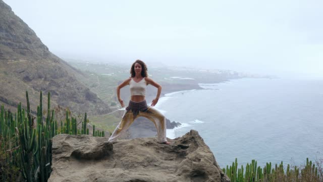 Mujer-joven-medita-en-la-cima-de-la-montaña
