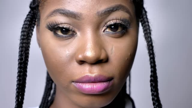 Close-up-Portrait-von-schönen-afrikanischen-Mädchen-Blick-auf-Kamera-mit-Stolz-und-Zuversicht-auf-grauen-Folie