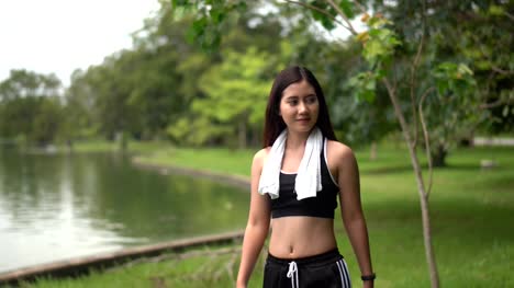 Mujer-bonita-con-ropa-de-deporte-caminar-ejercicio-pase-de-pantano-en-el-Parque