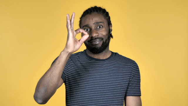 Okay-Sign-by-Casual-African-Man-Isolated-on-Yellow-Background