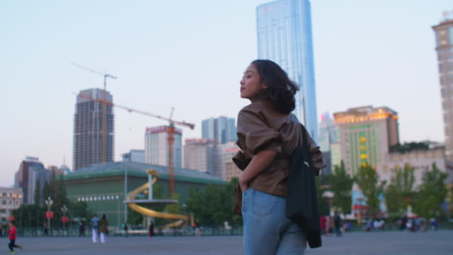 Pretty-young-asian-woman-running-in-the-city-at-evening,-4k
