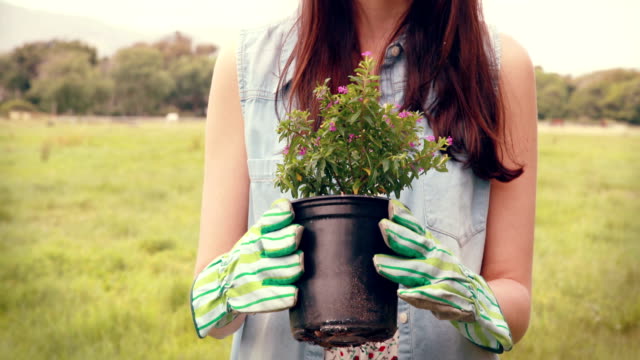Happy-woman-holding-potted-flowers