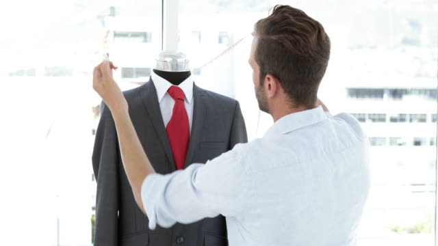 Handsome-tailor-measuring-suit-on-mannequin
