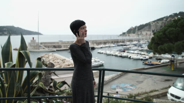 Mujer-joven-turista-conversaciones-en-el-teléfono-móvil-en-la-playa