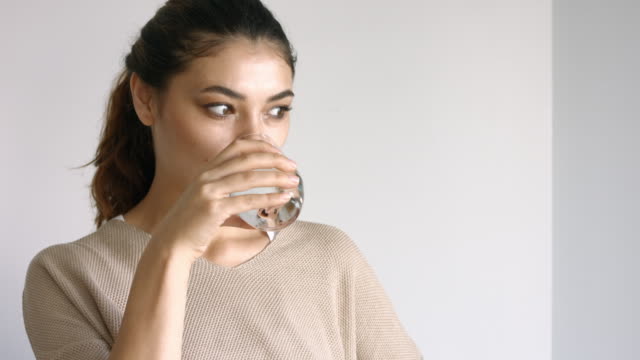 Junge-Frau-trinkt-ein-Glas-Wasser