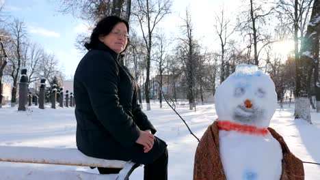 Young-Woman-Building-Snowman-in-the-Park.-In-the-winter