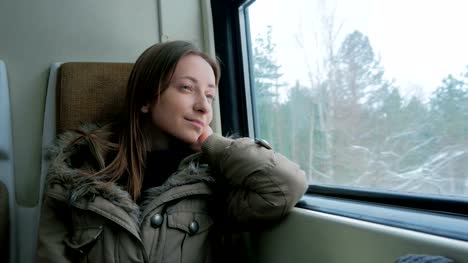 Nachdenkliche-Frau-entspannen-und-suchen-aus-einem-Zugfenster