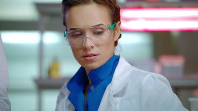 Investigador-de-laboratorio-en-laboratorio.-Primer-plano-de-la-científica-femenina-en-gafas-de-seguridad