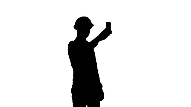 Trabajador-de-la-construcción-Silhouette-usando-el-teléfono-para-tomar-selfies