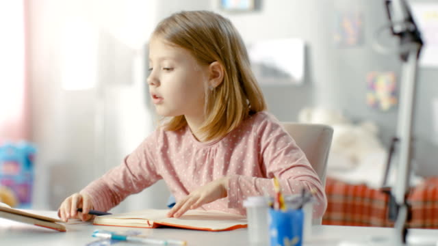Smart-Little-Girl-Does-Homework-in-Her-Room.