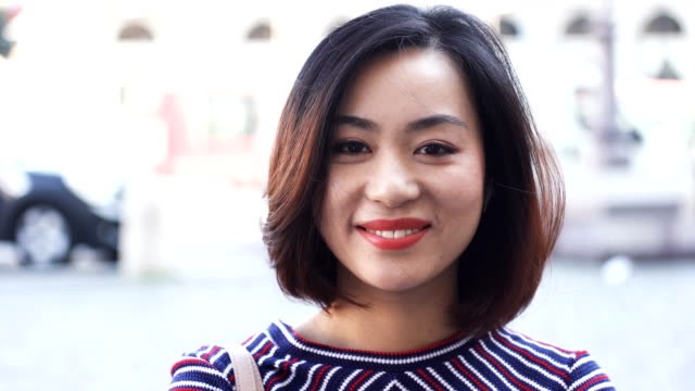 Junge-asiatische-Frau-In-Stadt-am-Tag-Lächeln-glückliches-Gesicht-Porträt