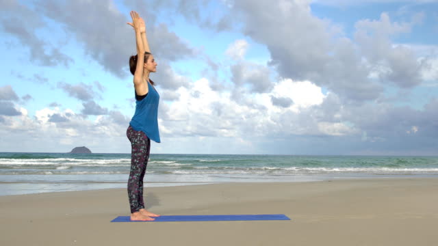 Frau-praktizieren-Yoga-am-Strand-bei-Sonnenuntergang.-Übungen-Ruhe-und-Harmonie.