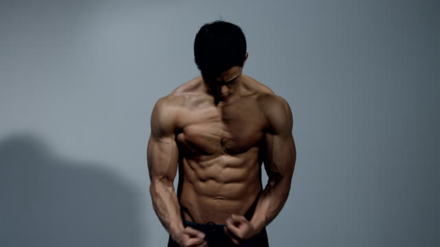 Fitness-Modell-zeigt-seinen-muskulösen-Oberkörper-2
