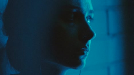 Cyberpunk-young-girl-portrait-in-deep-blue-street-lights.-Generation-z-person-in-low-neon-light.