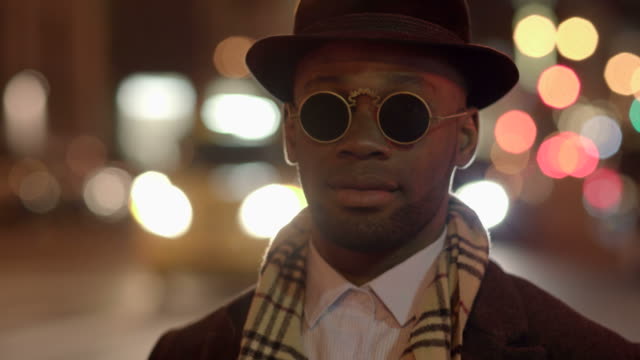 Young-Man-with-African-American-Ethnicity-Wearing-Old-Classic-Look.-Having-Fun-in-the-Big-City-with-Sunglasses,-Hat-and-Scarf.