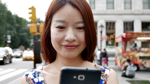 Schöne-chinesische-Frau-SMS-und-im-Gespräch-mit-dem-Telefon-in-der-Stadt.-Glücklich-zu-sein,-Lächeln-und-Spaß-haben.