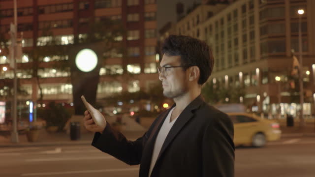 Young-Asian-Man-Using-Tablet-in-Urban-Environment.-Symbolizes-Global-Communication,-Digital-Technology,-Modern-Lifestyle