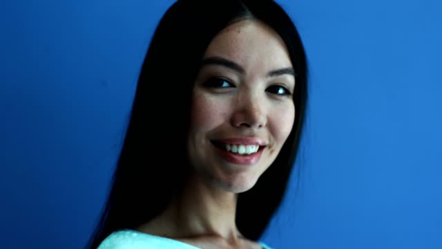Porträt-einer-positiven-Frau-lächelnd-auf-blauem-Hintergrund