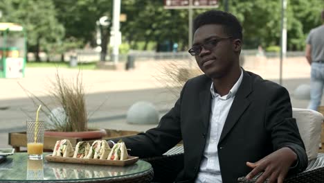 Müde-afroamerikanischer-Geschäftsmann-sitzen-im-Café,-auf-der-Suche-zu-langweilen-oder-satt