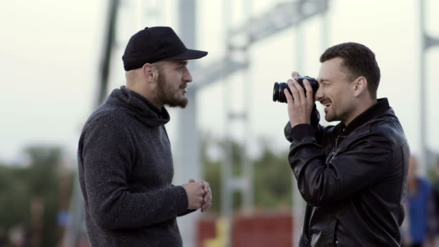 Two-men-have-fun-at-the-bridge-with-camera
