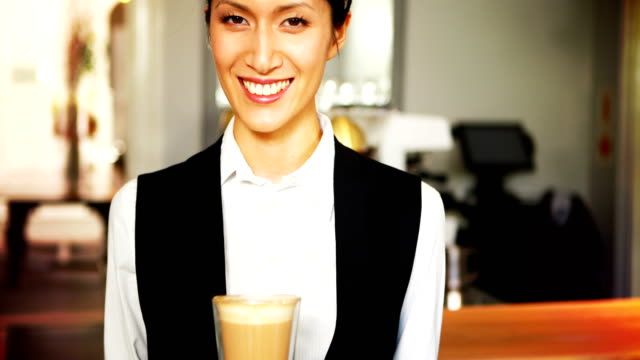 Portrait-of-smiling-waitress-holding-tray-of-coffee-glass