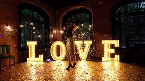 Beautiful-girl-posing-against-a-background-of-shining-letters