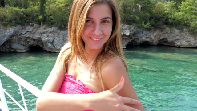 Close-up-Portrait-junge-Frau-lächelnd-auf-Azure-Meer-Hintergrund-stehend