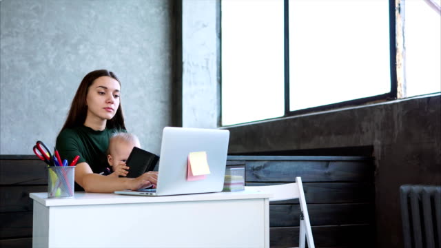 Mujer-que-trabaja-en-la-oficina-con-su-hijo