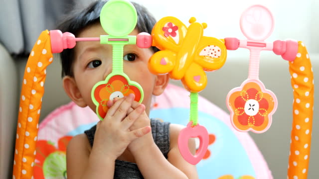 niedliche-Baby-Boy-mit-Hand-spielen-Spielzeug-in-den-Mund-gelegt