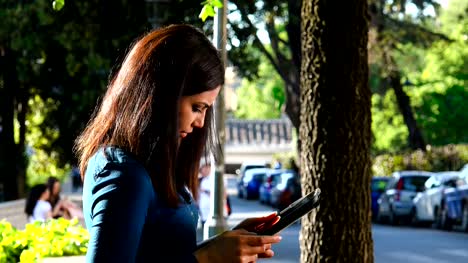 Beautiful-asian-woman's-profile-in-a-park-uses-the-tablet