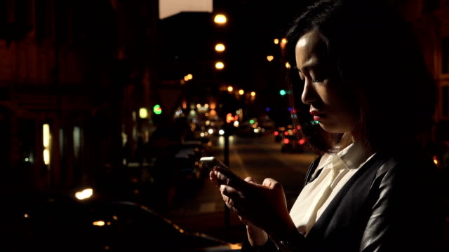 Profil-der-traurige-junge-Chinesin-Weinen,-hält-das-Smartphone-auf-der-Brust