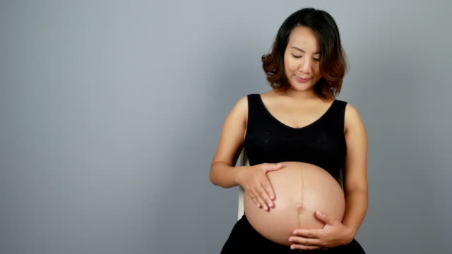 Schöne-schwangere-Frau-auf-grauem-Hintergrund