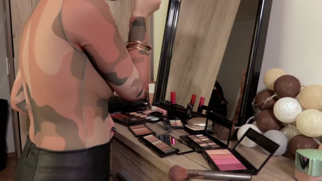 Woman-apply-makeup-near-mirror