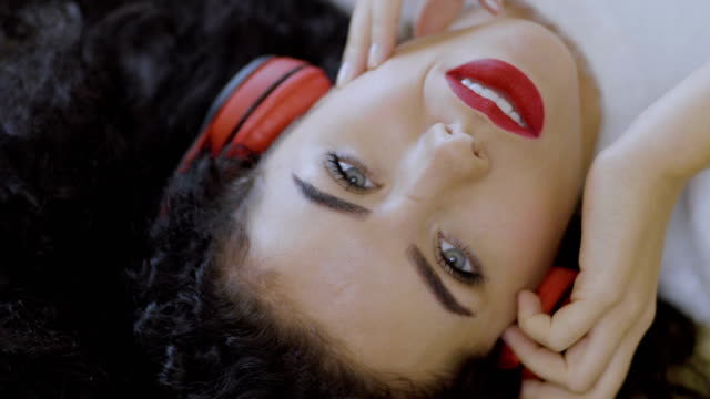 Porträt-des-jungen-Mädchens-mit-roten-Lippen-genießt-Musik-im-Kopfhörer